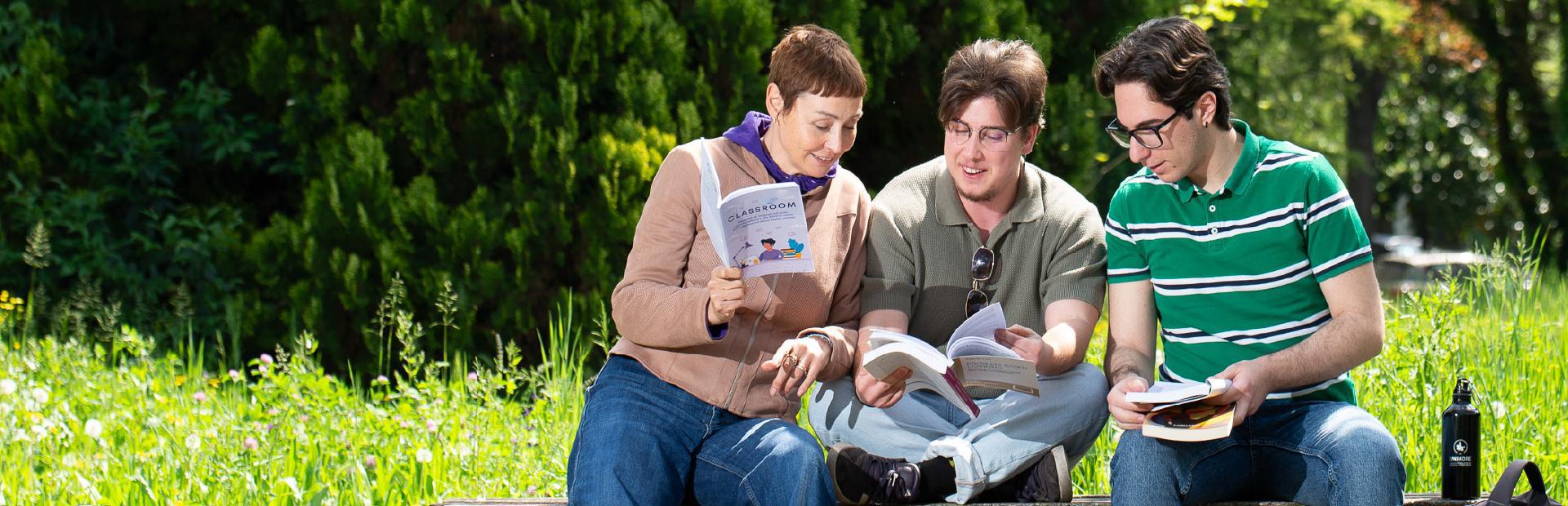 Studenti al parco che consultano dei libri